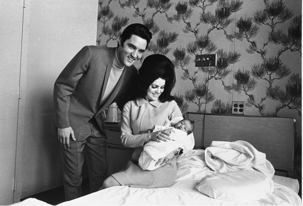 Lisa Marie Presley poses for her first picture in the lap of her mother, Priscilla, on Feb. 5, 1968, with her father, Elvis Presley.