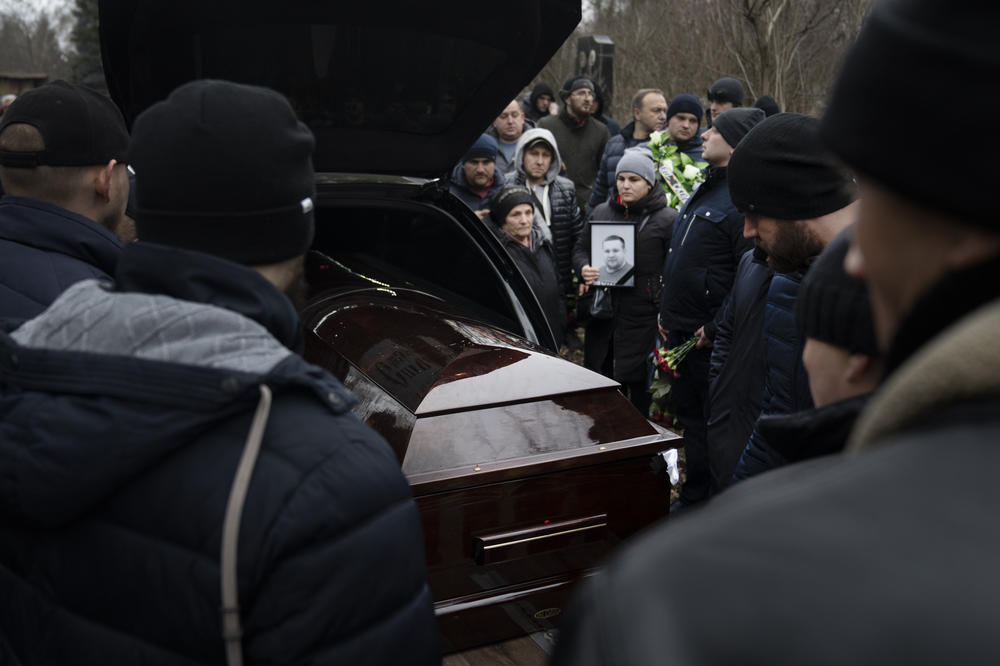 The coffin of boxing coach Mykhailo Korenovsky arrives at a cemetery on the outskirts of Dnipro, Ukraine, on Tuesday. Korenovsky died in the residential building that was hit in Dnipro on Saturday.