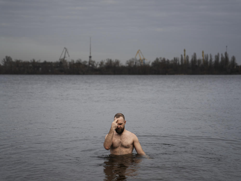 Nikolai Pastuchenko crosses himself as he takes a dip into the Dnipro River in Dnipro, Ukraine, on Thursday.
