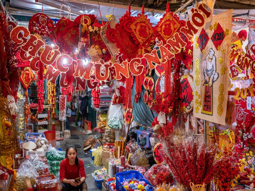 Sitting among Lunar New Year decorative items, a vendor waits for customers at her shop in Hanoi on Jan. 14.