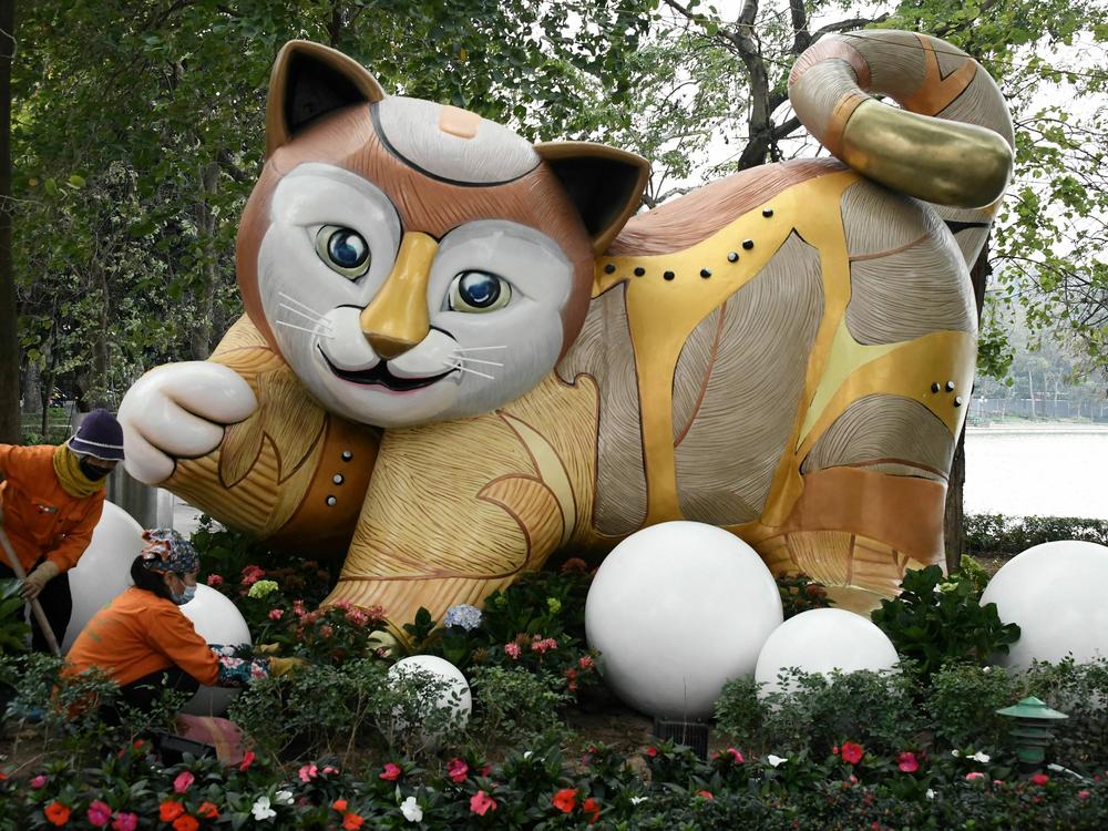 Workers plant flowers in front of a cat statue by Hoan Kiem Lake in Hanoi on Tuesday. These animal statues are seen every year around Vietnam for the Lunar New Year.