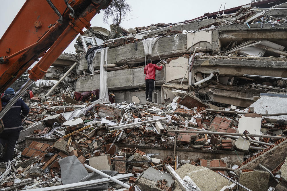 A man searches for people in the rubble of a destroyed building in Gaziantep, Turkey, on Monday, Feb. 6, 2023.