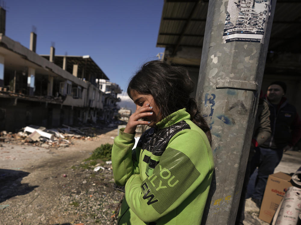A girl stands next to destroyed buildings in Antakya, southern Turkey on Wednesday.