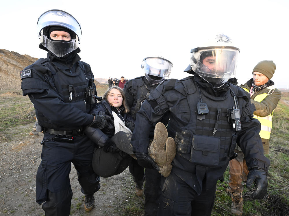 Police officers carry Thunberg out of a group of protesters and away from the edge of the Garzweiler II opencast lignite mine in North Rhine-Westphalia, Germany.