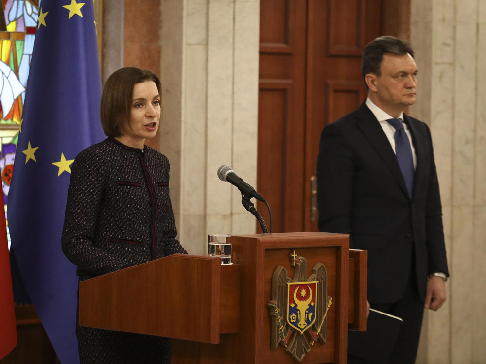 Moldovan Prime Minister designate Dorin Recean waits as President Maia Sandu (left) announces he is appointed to form a new government in Chisinau, Moldova, on Friday.
