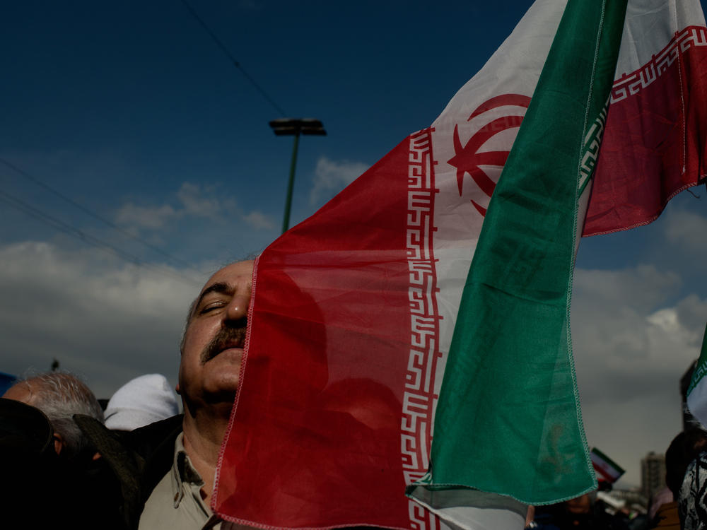 A man holds an Iranian flag during a parade in western Tehran.