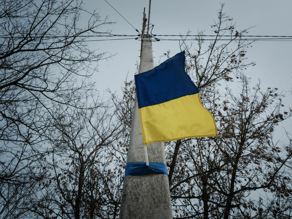 A Ukrainian flag adorns an electrical post in Kupiansk, in the Kharkiv region, on Feb. 13, nearly a year after the Russian invasion of Ukraine.