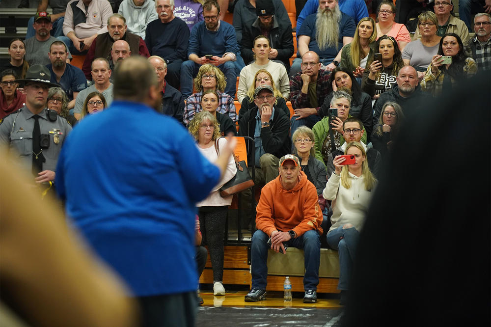 Community members listen to East Palestine Mayor Trent Conaway during a town hall meeting Wednesday night.
