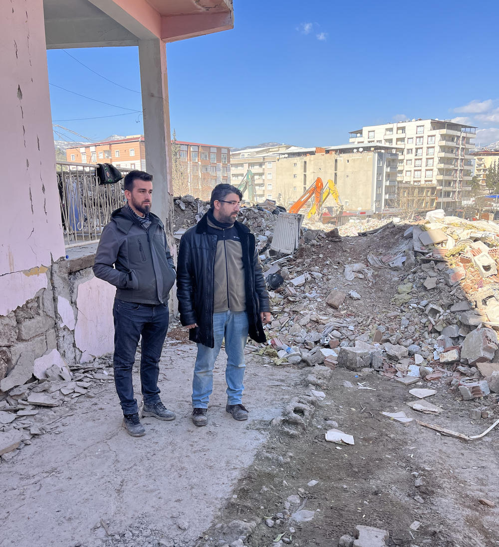 Ali Kafadenk (left) and his brother Abdullah look at the rubble of Ali's apartment building in Islahiye, Turkey. The building was reduced to rubble in the Feb. 6 earthquake that hit Turkey and Syria.