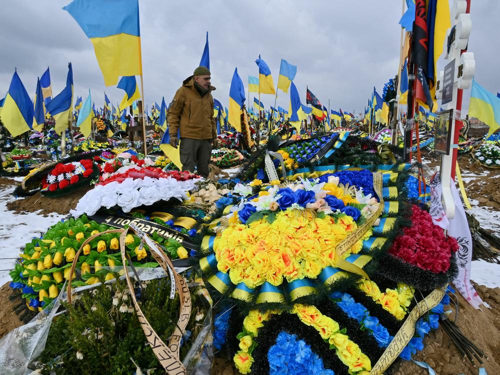 A man walks among graves of Ukrainian soldiers in the 