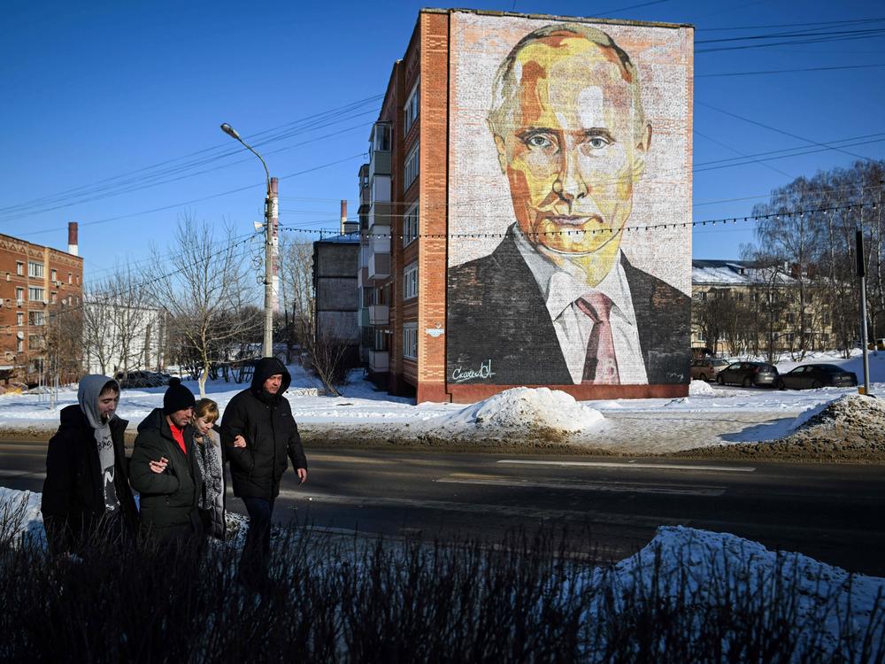 Pedestrians walk past a large mural of Russian President Vladimir Putin on a residential building in Kashira, a town south of Moscow, on Thursday.