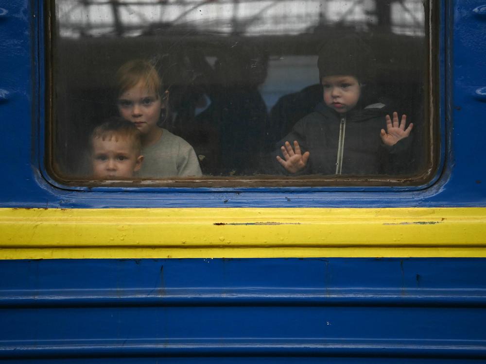 Children look out from a carriage window as a train prepares to depart from a station in Lviv, Ukraine, on March 3, 2022. The U.N. says more than 8 million Ukrainians fled to Europe since the start of the invasion.