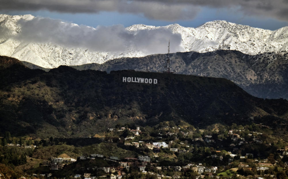 Storm clouds and snow over the San Gabriel mountain range are seen behind the Hollywood sign in Los Angeles on Sunday.