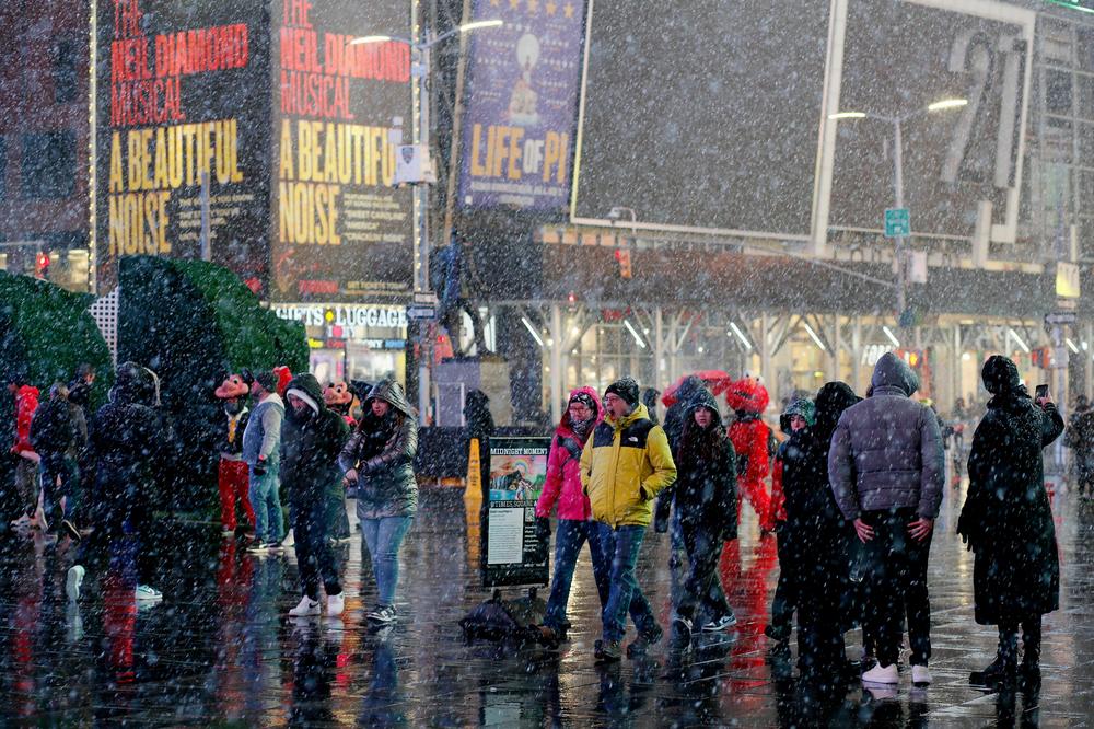 People visit Times Square during a snowfall on Monday in New York City.