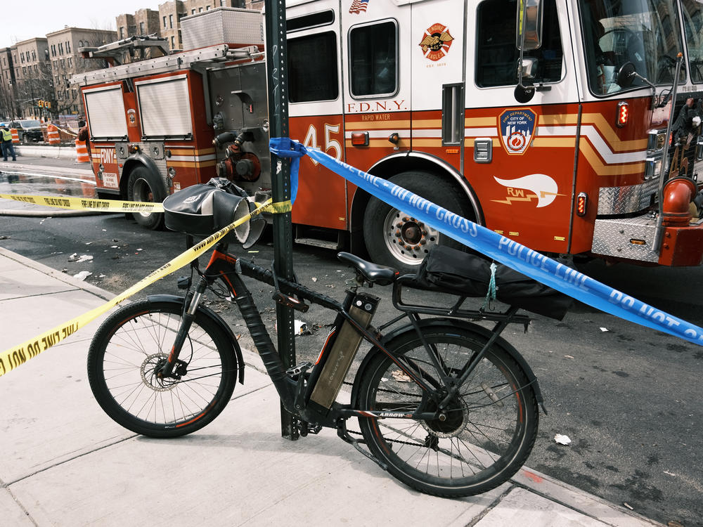 An electric bike parked near a Bronx supermarket that was destroyed in a fire that officials say was caused by a faulty lithium-ion scooter battery.