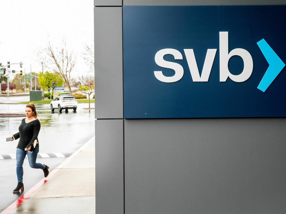 A property manager representative passes a sign at Silicon Valley Banks headquarters in Santa Clara, California on March 10, 2023.