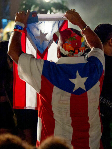 Miembros de la audiencia usan la bandera de Puerto Rico mientras Bad Bunny se presenta en el Yankee Stadium en la ciudad de Nueva York.