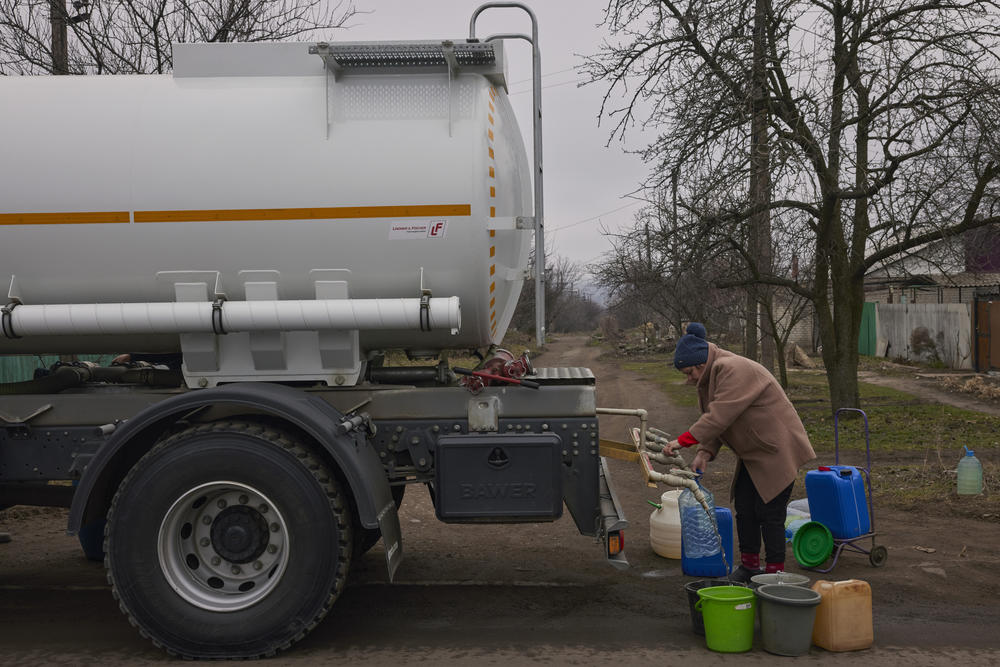 A local resident fills buckets and bottles with water from a water truck on March 20, 2023 in Konstantinivka, Ukraine. The UN says millions of Ukrainians have lost access to clean water.