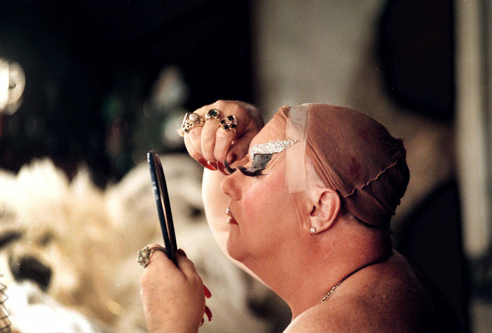 Walter Cole delicately attaches his eyelashes in the basement dressing room of his club in Portland, Ore., on Dec. 9, 1998, as the transformation to Darcelle takes shape.