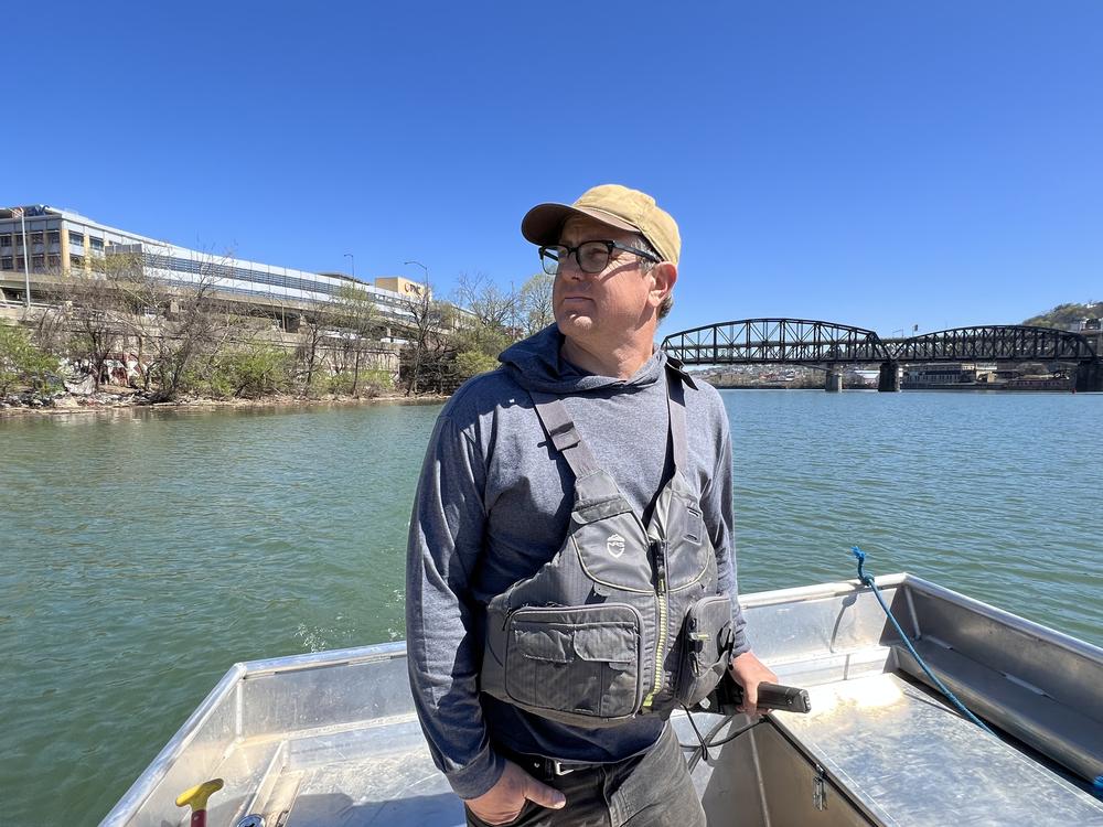 Evan Clark steers a boat on the Monongahela River, one of two tributaries that converge to form the Ohio River in Pittsburgh, Pa. Clark works with Three Rivers Waterkeeper, an environmental nonprofit that works to protect the rivers.
