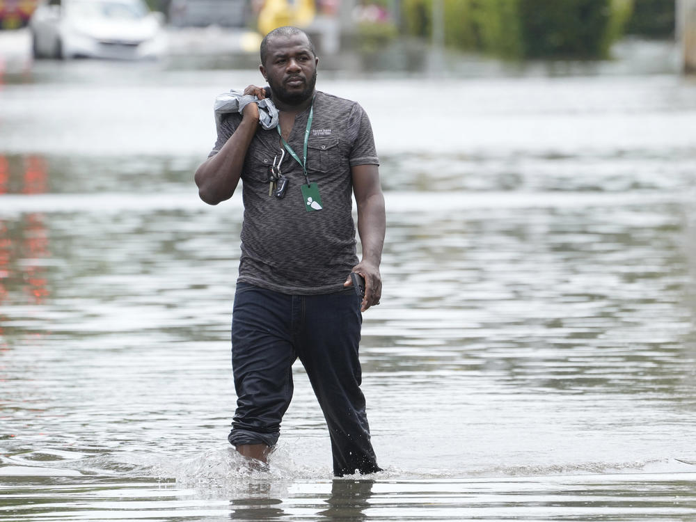 A man walks out of a flooded Fort Lauderdale neighborhood on April 13. Florida Gov. Ron DeSantis is asking the Biden administration to declare Broward County a disaster area due to flooding earlier this month after record rainfall.