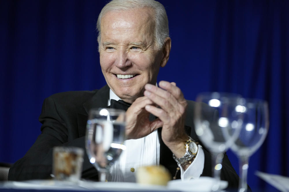 President Joe Biden claps as comedian Roy Wood Jr., a correspondent for <em>The Daily Show</em>, speaks during the White House Correspondents' Association dinner at the Washington Hilton in Washington, D.C., on Saturday.