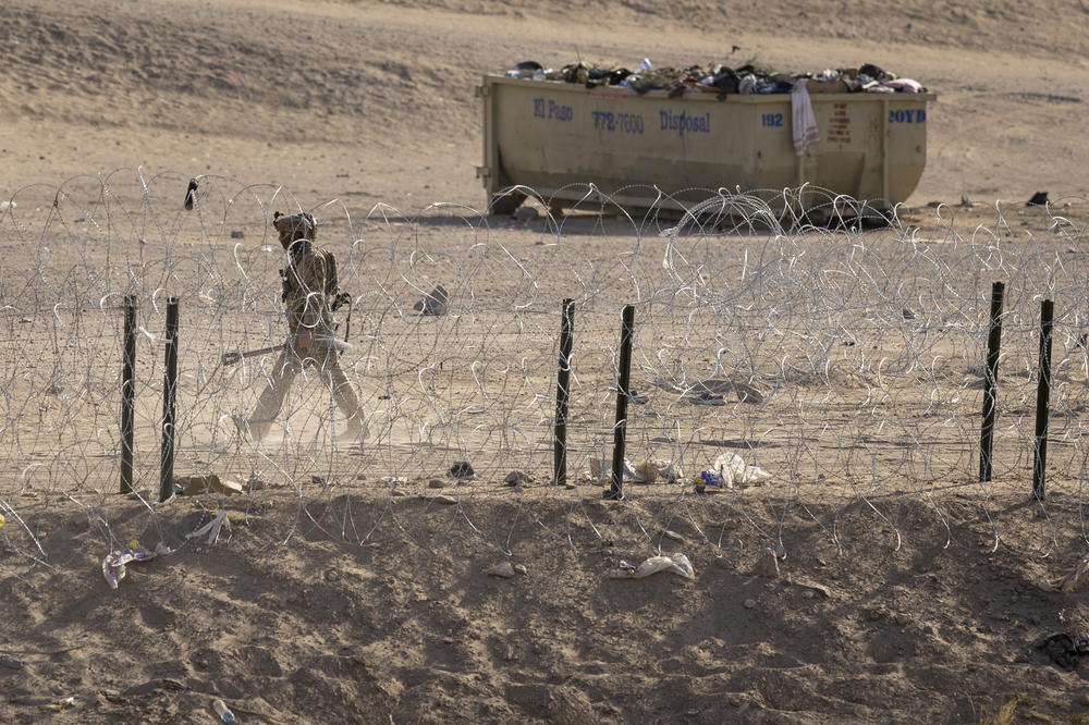 Texas National Guard soldier walks through an emptied-out migrant camp at the U.S.-Mexico border.