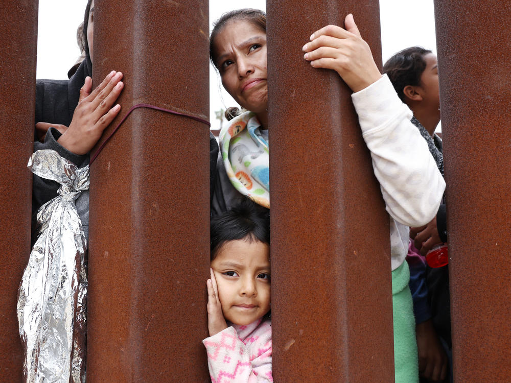A mother and daughter await volunteer assistance while stuck in a makeshift camp at the U.S.-Mexico border.