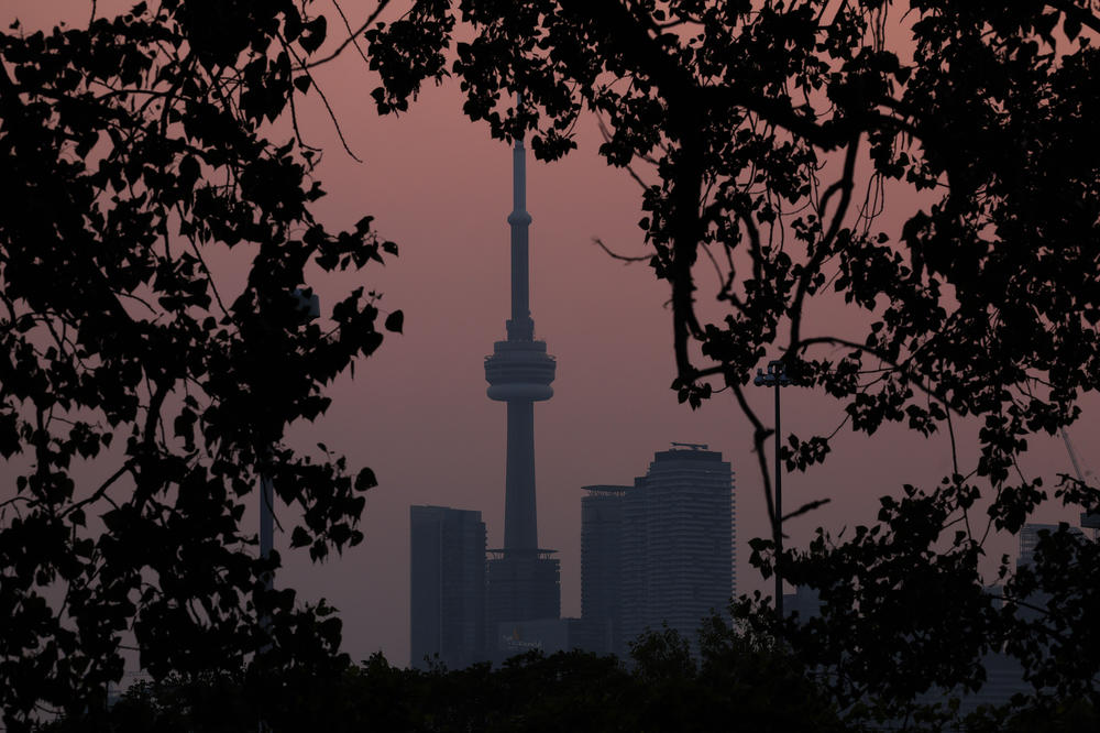 Smoke from forest fires in Northern Ontario and in Quebec contribute to pink hazy sunset in the city from the Cherry Beach over Toronto on June 6, 2023.