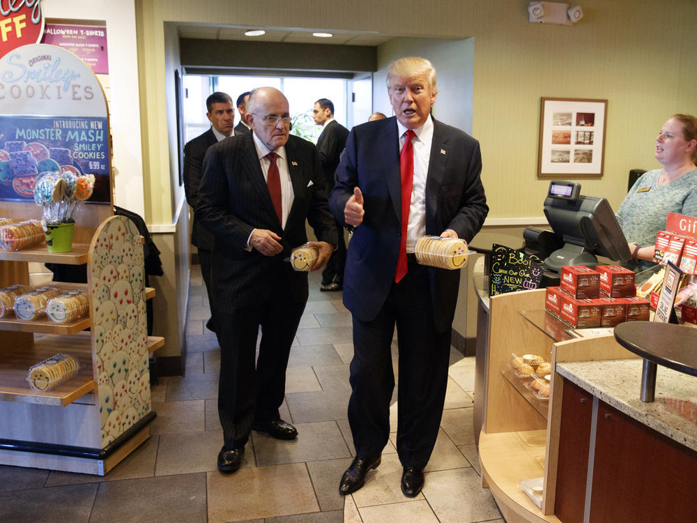In this Oct. 10, 2016, file photo, former New York mayor Rudy Giuliani, left, stands with then-Republican presidential candidate Donald Trump as he buys cookies during a visit to Eat'n Park restaurant in Moon Township, Pa.