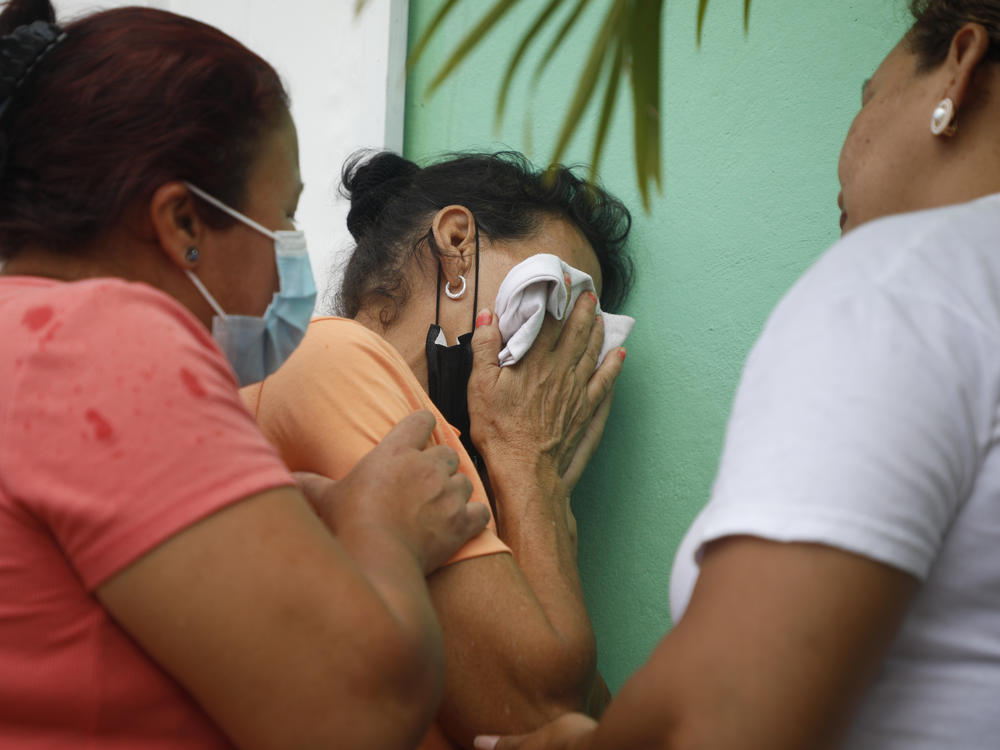 Relatives of inmates wait in distress outside the entrance to the women's prison in Tamara, on the outskirts of Tegucigalpa, Honduras, Tuesday, June 20, 2023.