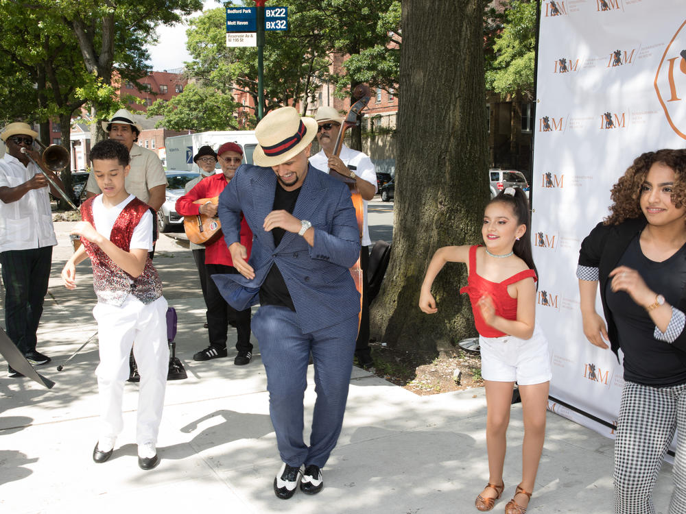 Eddie Torres Jr. and Princess Serrano dance with two young salseros at the first pop-up of the International Salsa Museum