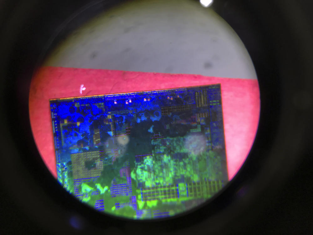 A Chinese microchip is seen through a microscope at the 21st China Beijing International High-tech Expo in Beijing, China, in 2018. China has imposed export curbs on two metals used in computer chips and solar cells, expanding a trade squabble with Washington.