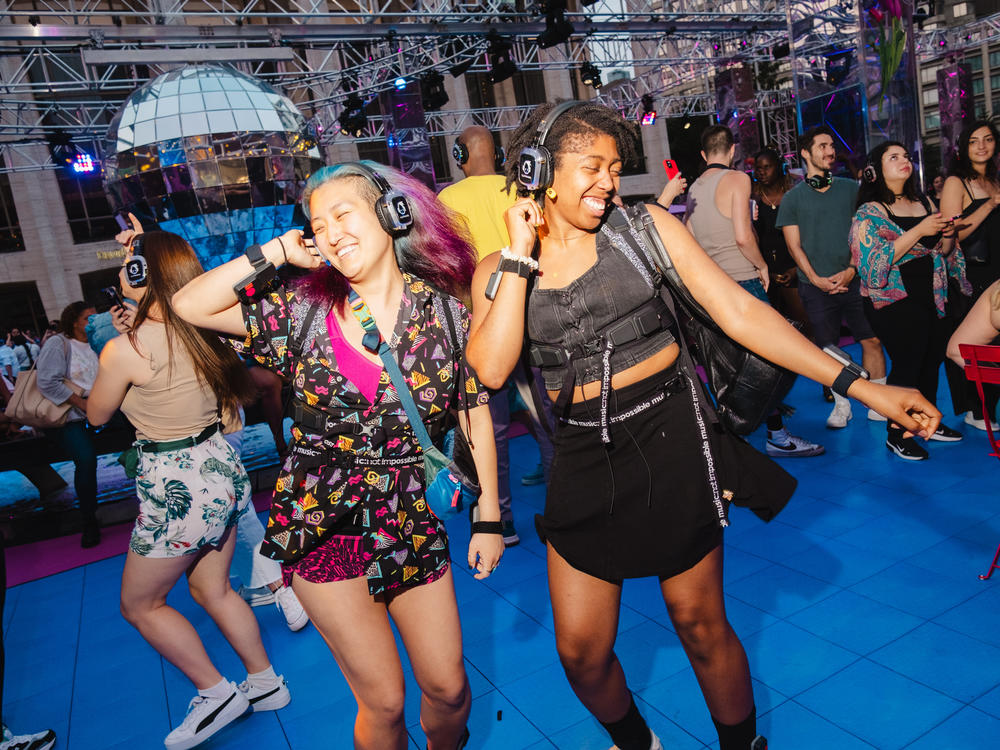 Concert goers dancing at the Silent Disco dance party at Lincoln Center, New York City on Saturday, July 1, 2023. Haptic suits designed for the deaf community were provided by Music: Not Impossible.