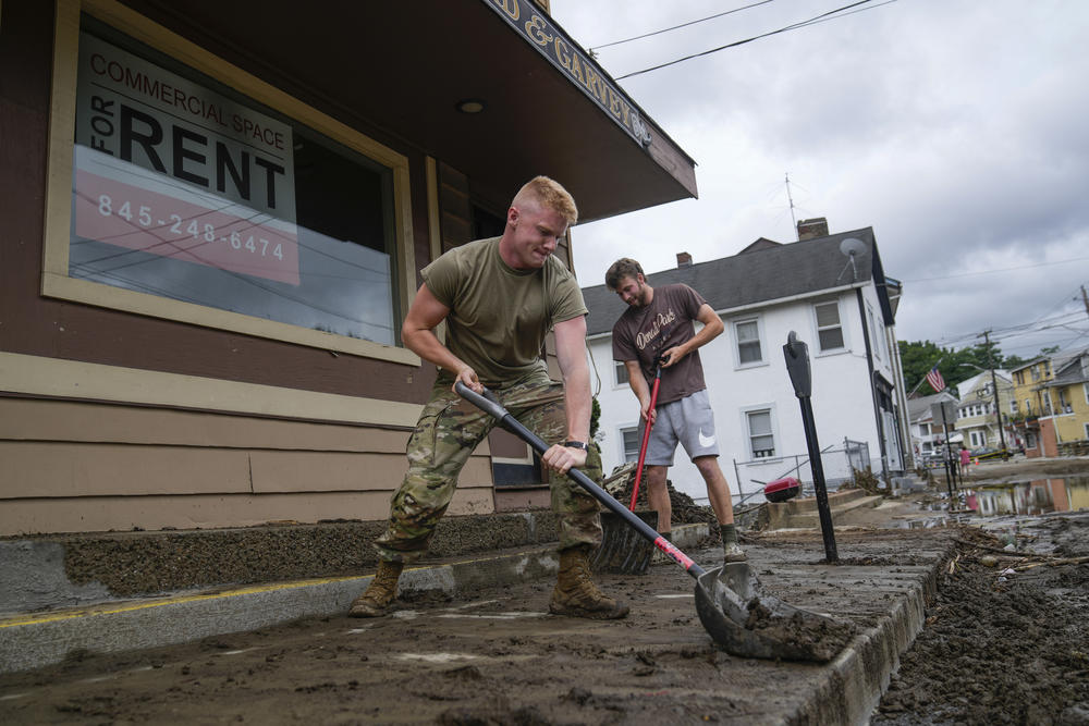 Volunteers help clear Main Street of debris after floodwaters subsided, Monday, July 10, in Highland Falls, N.Y.