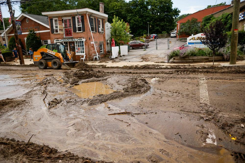 Workers remove mud from Main street after heavy rains in Highland Falls, N.Y., on July 10.