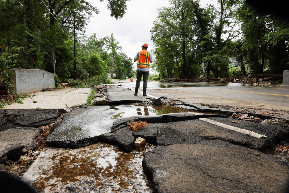 Workers survey a severely damaged road near Bear Mountain State Park following a night of heavy rain and flooding in Highland Falls, N.Y., on Monday, July 10.