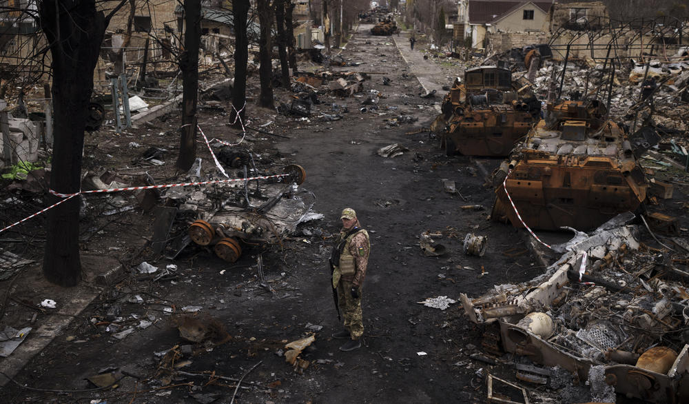 A Ukrainian serviceman stands amid destroyed Russian tanks in Bucha, on April 6, 2022, just days after the Russian forces were driven out.