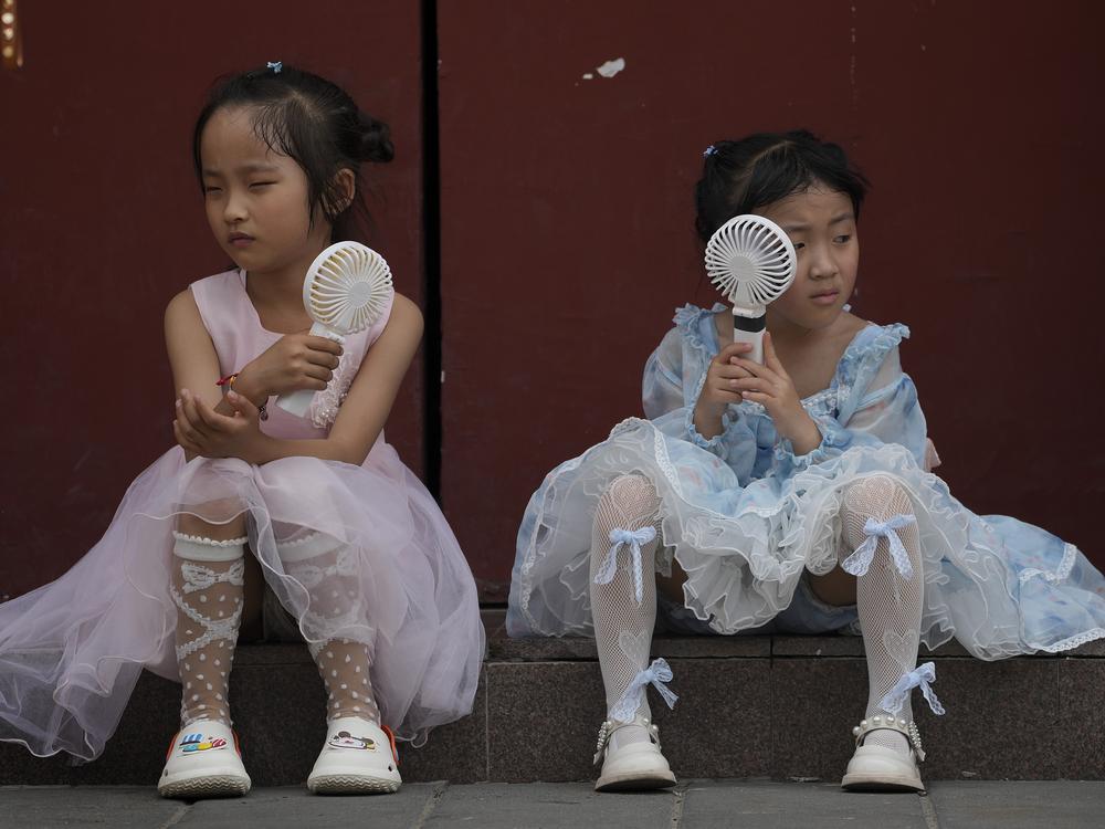 Children cool themselves with electric fans in Beijing on June 25, 2023. The National Oceanic and Atmospheric Administration says this was the hottest June on record globally.