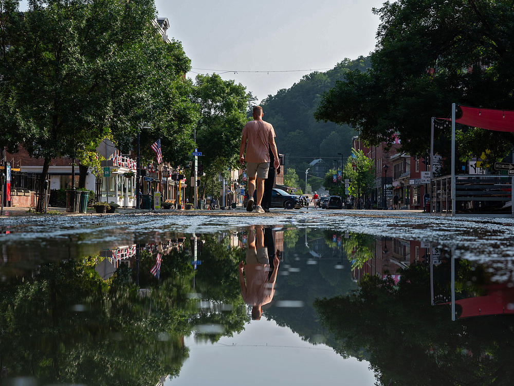 Residents walk along a muddy Main Street Tuesday in Montpelier, Vermont. The capital city saw nearly 7 inches of rainfall in just a matter of hours.