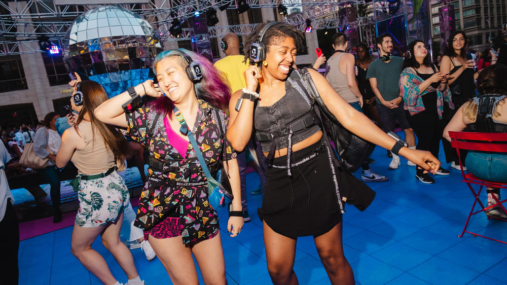 Concert go-ers dancing at the Silent Disco dance party at Lincoln Center, New York City on Saturday, July 1, 2023. Headphones and haptic suits designed for the deaf community so they can feel the beat were provided by Music Not Impossible.