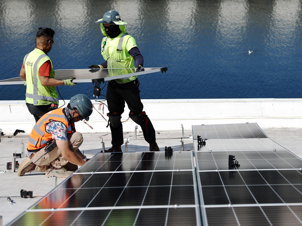 Workers install solar panels at the Port of Los Angeles in California.