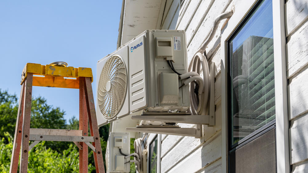 An air conditioner undergoes repair earlier this month in Austin, Texas. Record-breaking temperatures continue across large swaths of the U.S.
