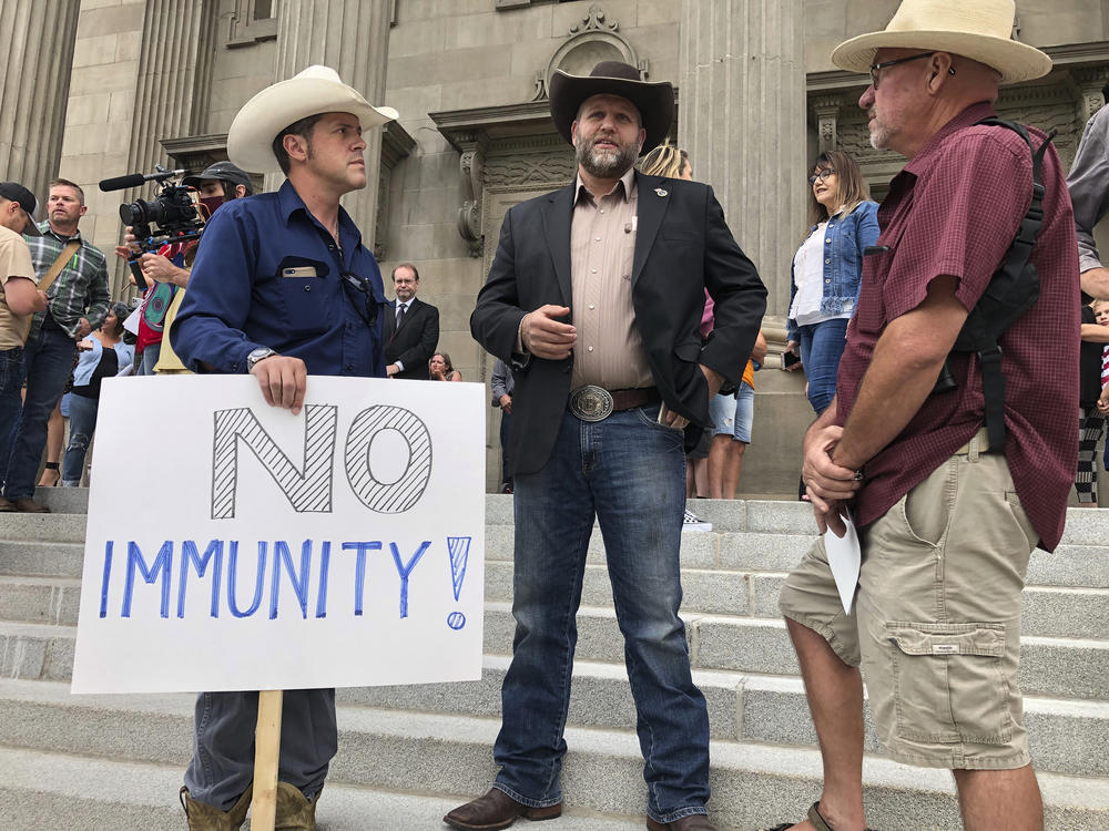 Ammon Bundy, center, who led a protest at a Boise hospital last year, stands on the Idaho Statehouse steps in Boise, Idaho, on Monday, Aug. 24, 2020.