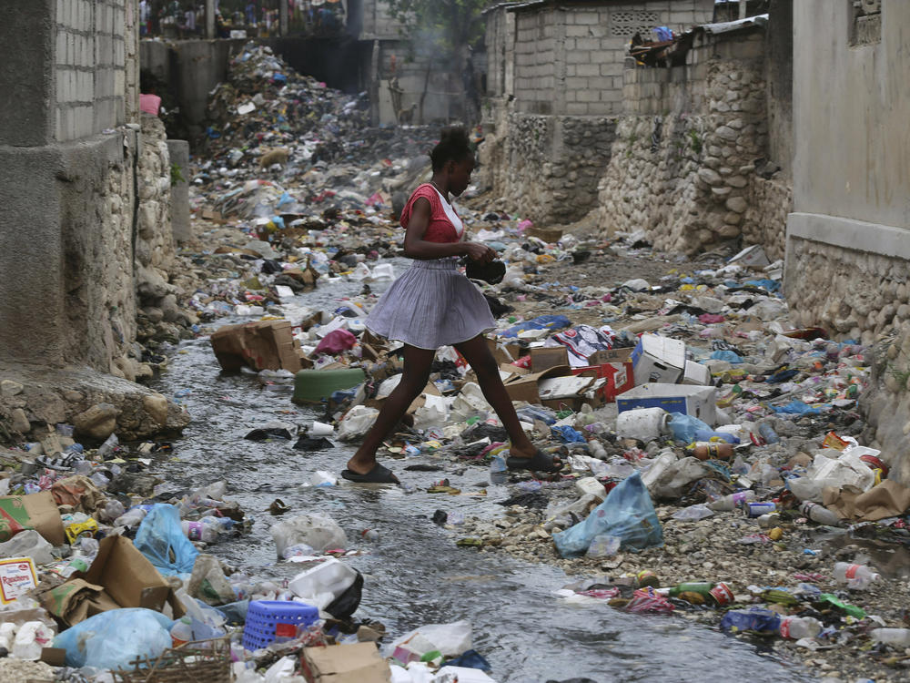 A girl walks through a ravine filled with garbage in Port-au-Prince, Haiti, on July 13.