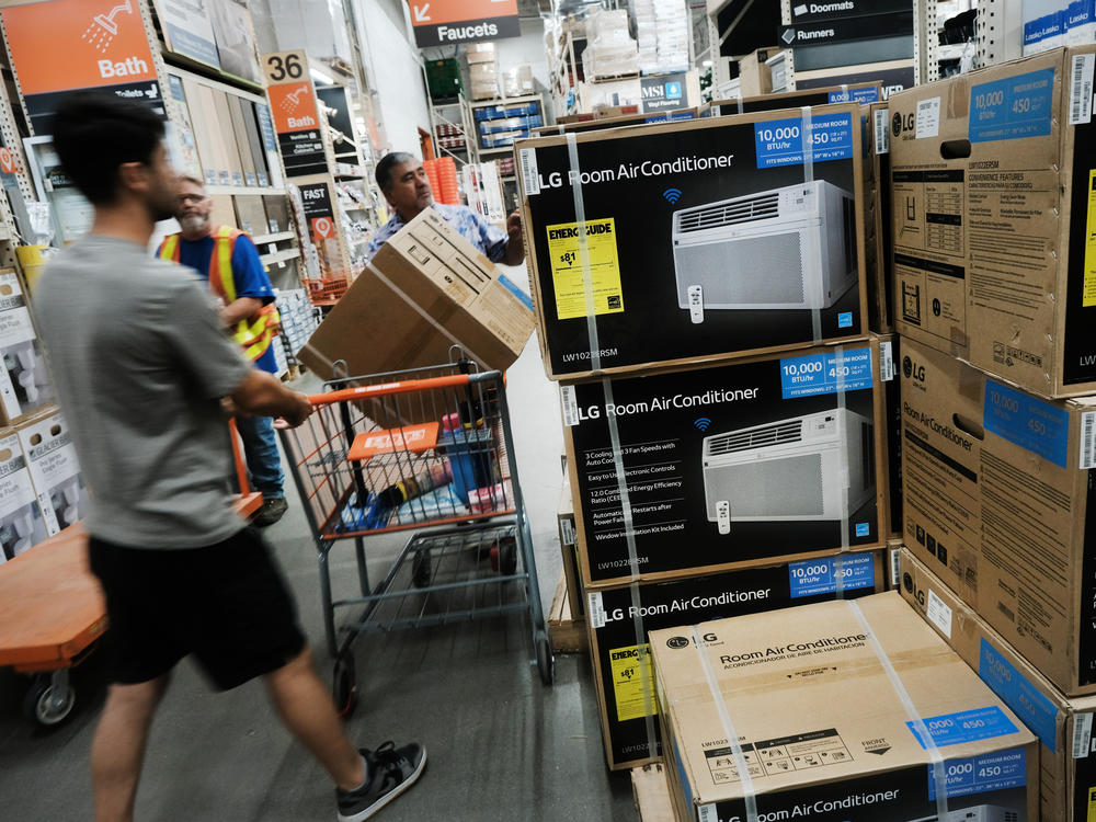 People shop for air conditioners during a heat wave last week in New York City. Many people who live in public housing can't afford such units or the utility bills that come with them — and there's no federal requirement for air conditioning.