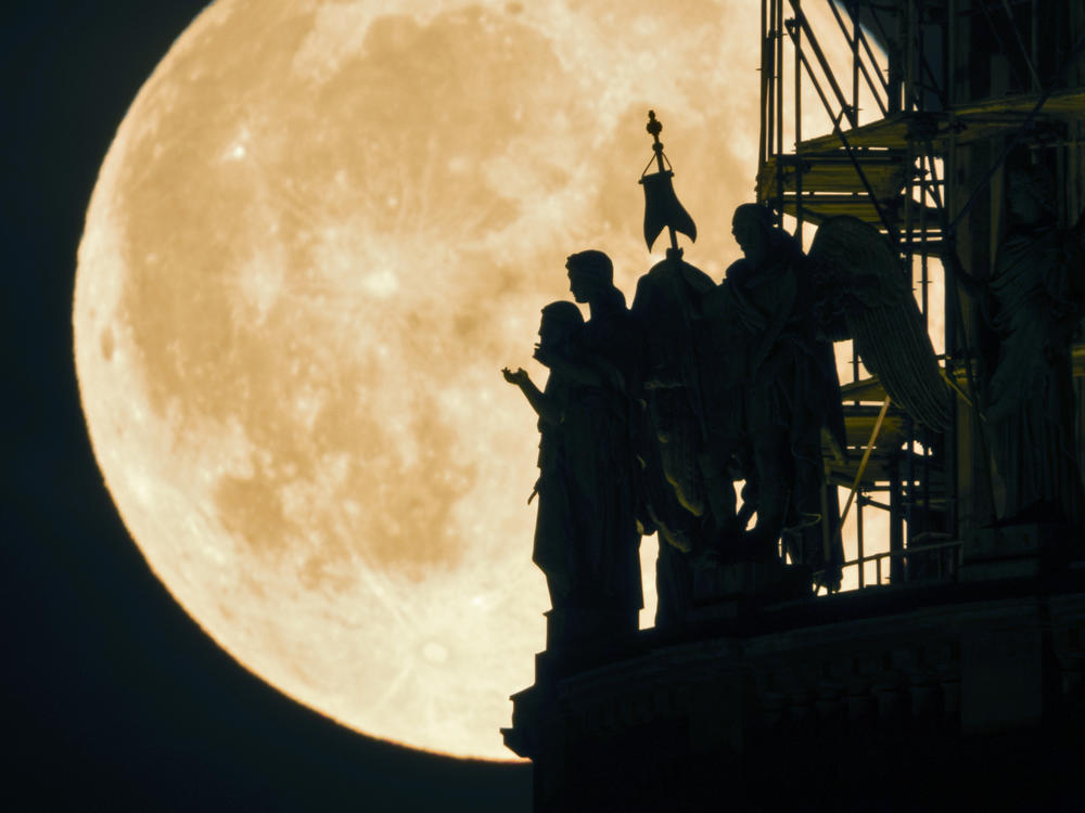 The first supermoon of the month rises behind angel sculptures on St. Isaac's Cathedral in St. Petersburg, Russia. The next lunar spectacle, a blue supermoon, will take place on Aug. 30.