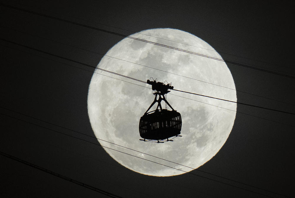 A cable car moves toward Sugarloaf Mountain as a supermoon rises in the night sky in Rio de Janeiro, Brazil, on Tuesday.