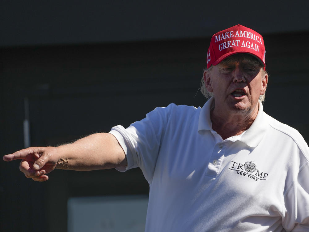 Former President Donald Trump talks to people in the crowd during the final round of the Bedminster Invitational LIV Golf tournament in Bedminster, N.J., Sunday, Aug. 13, 2023.