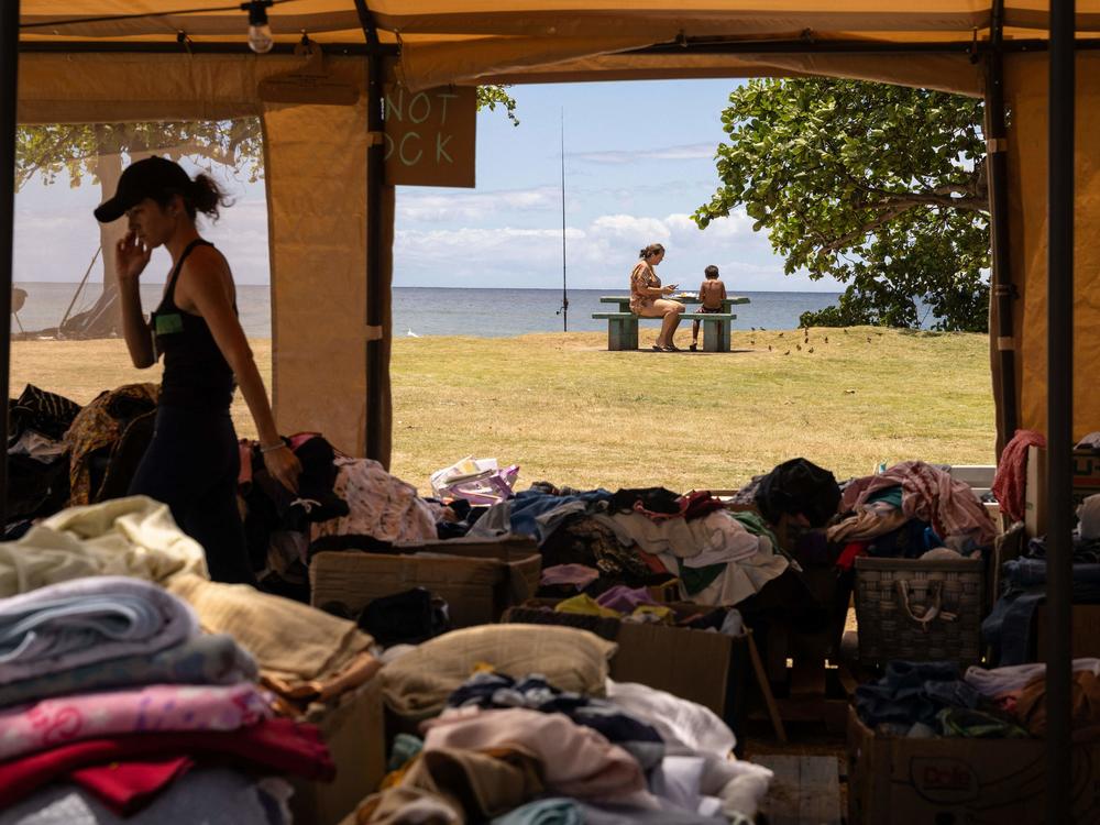 Donated clothes are piled at a distribution center at Honokawai Beach Park this week. The park has become a community gathering spot since the Lahaina fire. It's where Luz Vargas' son took his first steps and where she hopes to hold a memorial on Sunday — what would have been his 15th birthday.